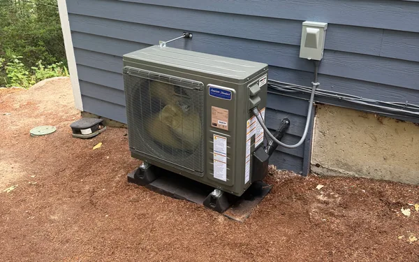 American Standard heat pump outdoor unit on riser pads beside a Pierce County, WA home
