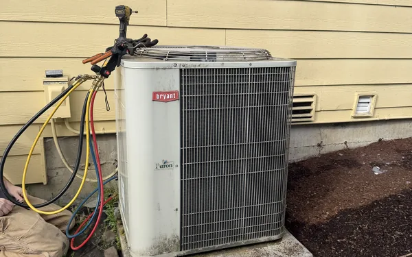 Pinnacle Air Control technician with refrigerant gauges on a Bryant outdoor unit in Pierce County, WA