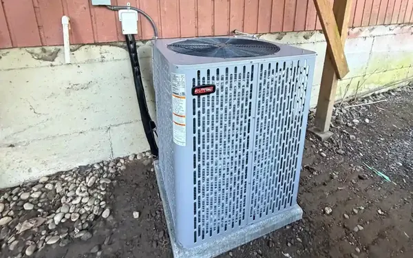 Older air conditioning condenser beside a Pierce County, WA home, waiting on a repair visit